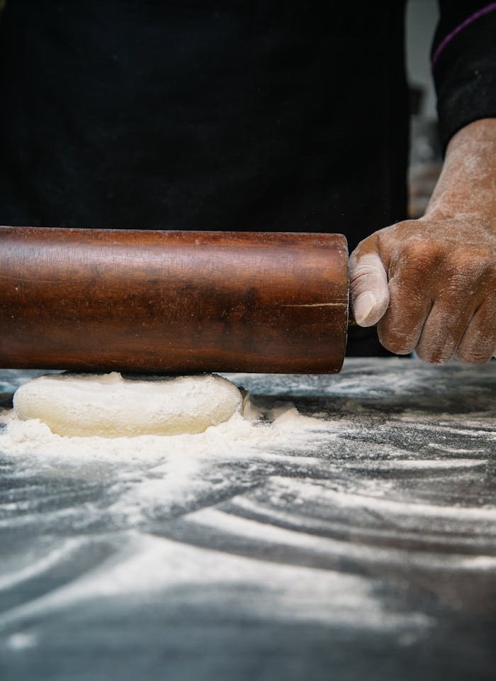 Person Using Brown Wooden Rolling Pin